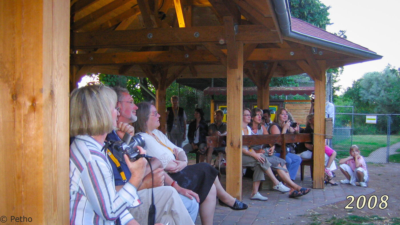 Vereinsmitglieder sitzen unter dem Dach des Pavillons